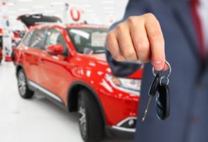 car dealer with a key. auto dealership and rental concept background.