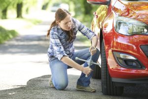 woman fixing a flat tire