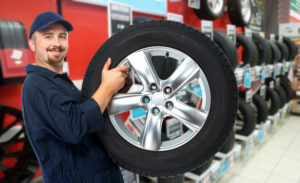 smiling mechanic holding tire
