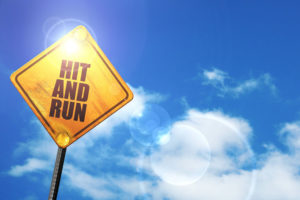 hit and run: yellow road sign with a blue sky and white clouds