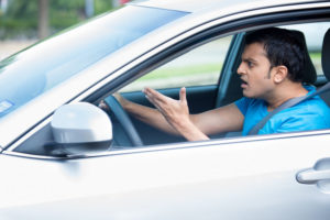 angry young sitting man pissed off by drivers in front of him