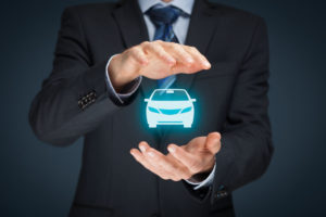 Businessman with protective gesture and icon of car for collision insurance.