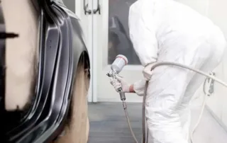 Auto body painter refinishing vehicle during collision repair at Orlando Auto Body