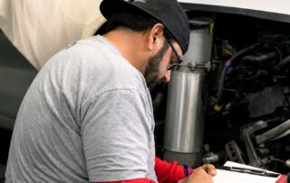 Collision repair technician inspecting vehicle damage at Orlando Auto Body