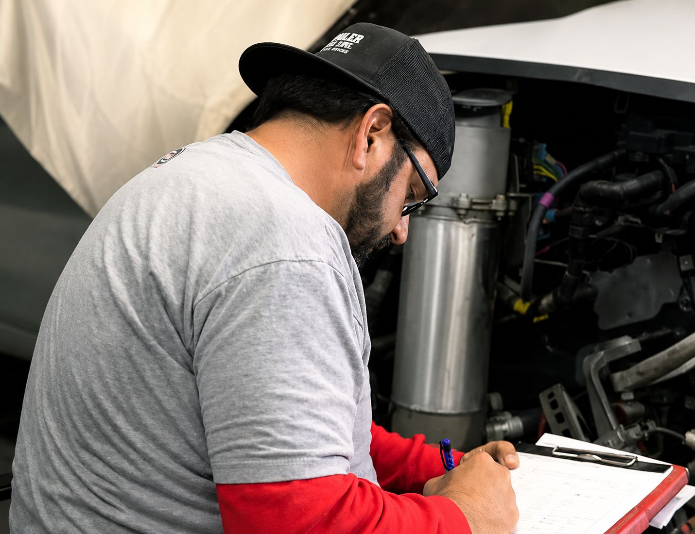 Collision repair technician inspecting vehicle damage at Orlando Auto Body