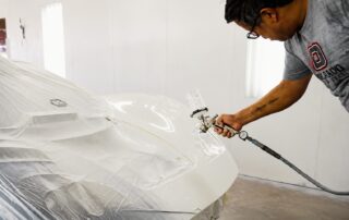 Paint technician performing collision repair paint matching at Orlando Auto Body in Arizona
