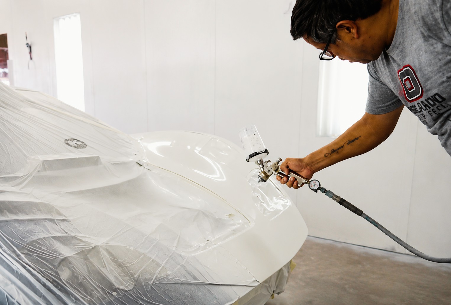 Paint technician performing collision repair paint matching at Orlando Auto Body in Arizona