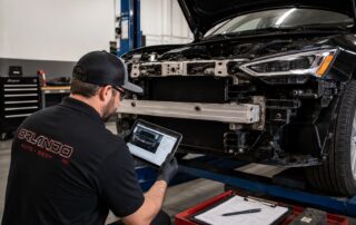 Collision repair technician inspecting hidden vehicle damage during a post-accident repair assessment at Orlando Auto Body.