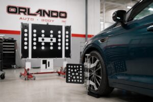 Blue vehicle undergoing ADAS calibration at Orlando Auto Body using advanced diagnostic equipment after collision repair.
